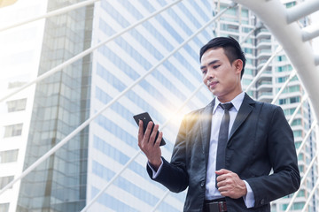 portrait of businessman hold the smartphone with building backgr