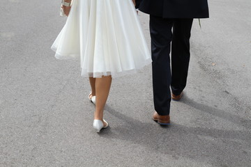 Rückansicht Hochzeitspaar auf dem Weg zum Standesamt als Element für Einladungskarten