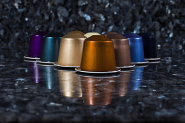 Cápsulas de cafetera centradas sobre fondo oscuro