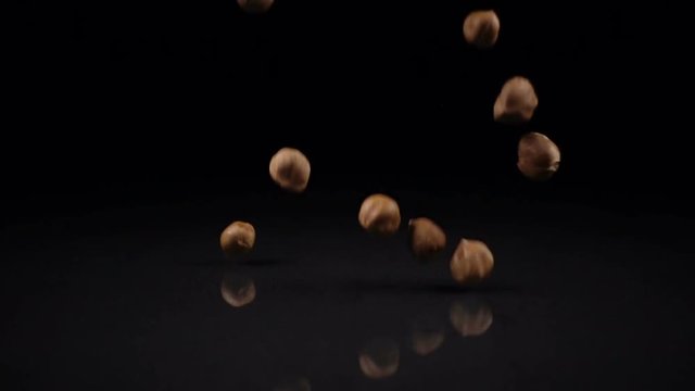 hazelnuts falling on a hard black surface