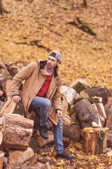 Young man sitting on dry stumps