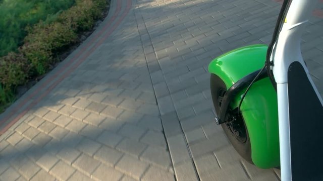 Fat wheel scooter on road. Green plants and pavement. High quality tires.