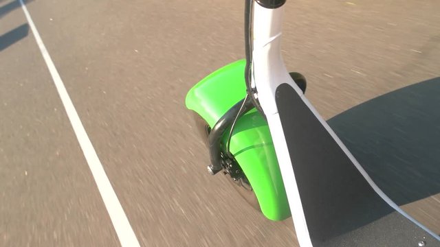 Fat wheel scooter in motion. Asphalt road at daytime. Quality tires from vulcanized rubber.