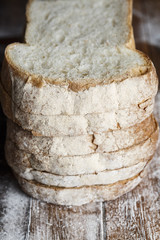 Fresh baked bread and sliced bread on rustic wooden table