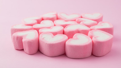 Pink heart-shaped marshmallow in with pink background