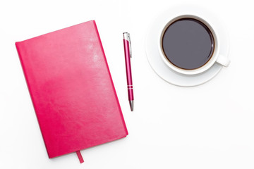 pink diary with pen and a Cup of black coffee on white background. business minimal concept for women. Flat lay, top view.
