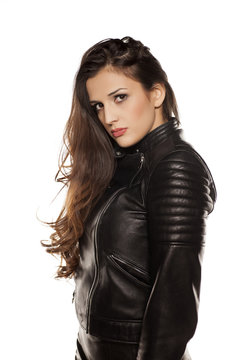 young beautiful woman in leather jacket on white background