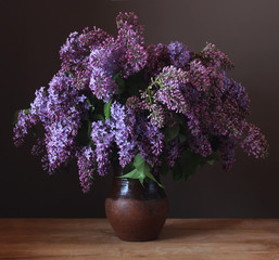 Bouquet of lilac in a clay jug.
