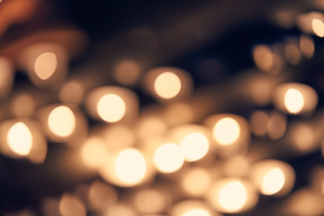 Blurred abstract background of candle lights, bokeh in cool vintage color tone