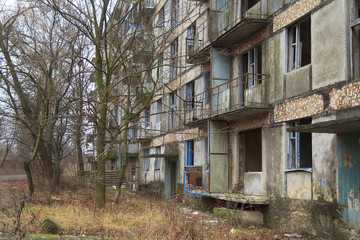 Fototapeta na wymiar Forsaken and deserted living building without windows and doors in a ghost town in Ukraine