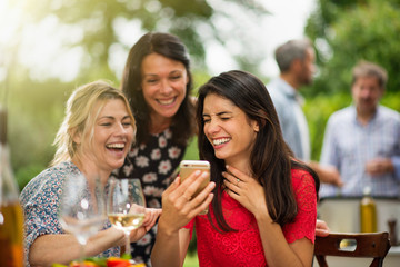 Group of female friends having fun while they watch photos