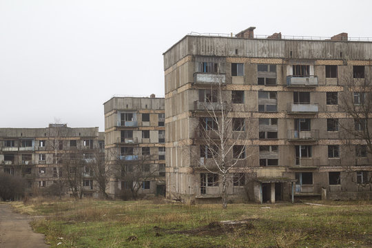 Three abandoned apartment houses without windows and overgrown with a grass in a ghost-town in Ukraine