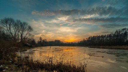 mysterious sunset over the freezing lake late autumn. landscape
