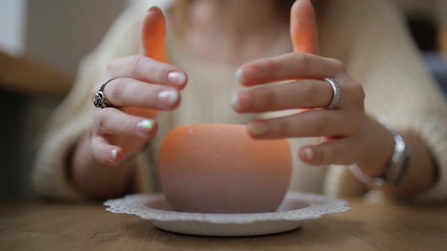 Woman warming hands above candle - cropped shot