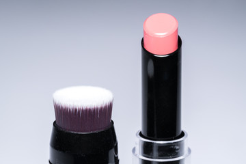 Beauty concept : Close up shot of Pink lipstick and lip brush with copy space.