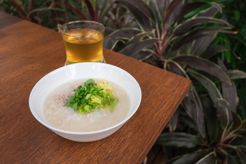 Pork porridge with ginger and coriander in bowl.