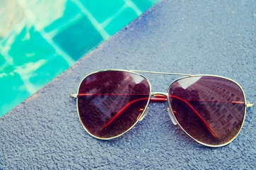 Brown funky sun glasses near swimming pool.Outdoor shot using na