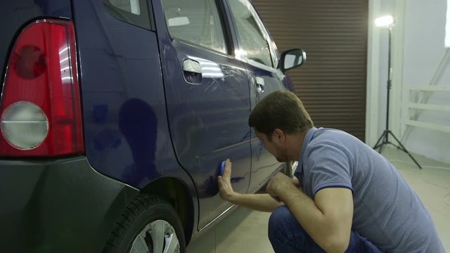 Master rubs car before polishing, the preparatory process