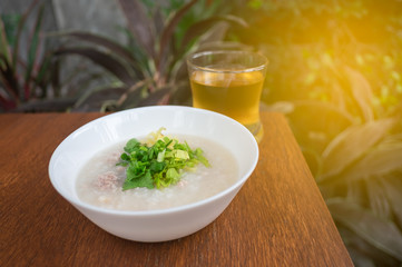 Pork porridge with ginger and coriander in bowl.