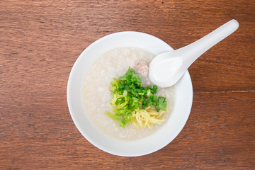 Pork porridge with ginger and coriander in bowl.