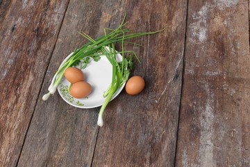 fresh chicken egg on a plate  and onion in wooden table