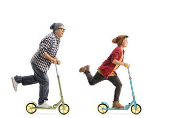 Mature hipster and a boy riding scooters