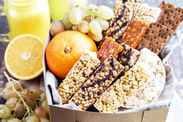 Cardboard box with muesli bars and fruits