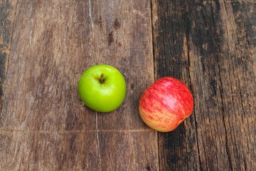 red and green apple on wooden background, top view and copy space