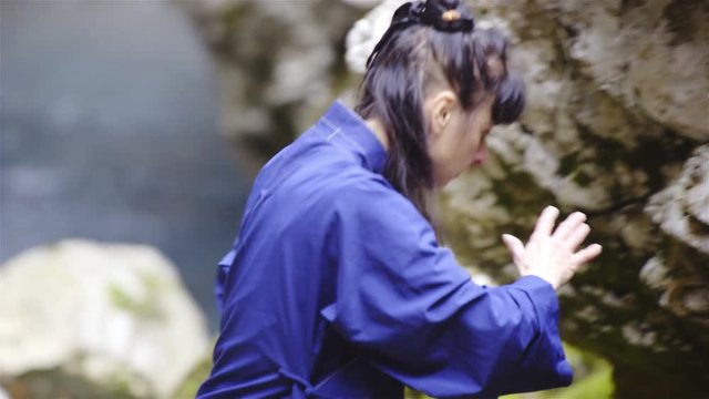 Woman in blue kimono stretch hands around making form exercise 4K
