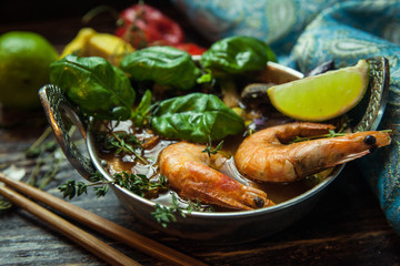 Shrimps or prawns in curry sauce on a plate with basil and lime. Indian and Asian cuisine