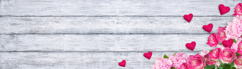 Fototapeta na wymiar Roses and hydrangeas with hearts on background of shabby wooden
