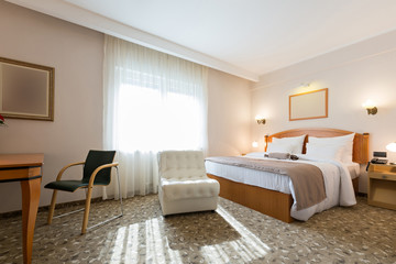 Interior of a new modern hotel double bed bedroom in the morning