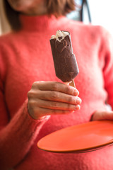 Woman eating chocolate covered popsicle