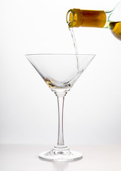 White wine pouring in a glass from  bottle