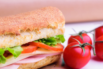 Fresh crusty baguette with ham, cheese, tomato and green salad