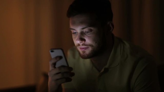 young man with smartphone at night