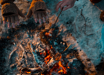 People on the nature of fried bacon on the fire and warm hands