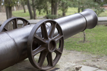 Old cast-iron cannon. The trunk of an antique cannon.