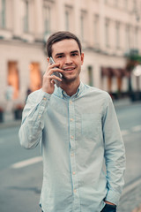 Handsome young man talking on cellphone in the city
