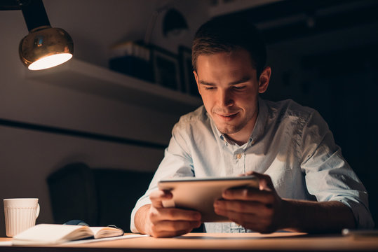 Young businessman working using a tablet late at night