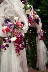 Look from below at wedding altar decorated with pink, violet and