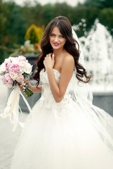 Fototapeta na wymiar Tender bride with long dark hair and pink wedding bouquet