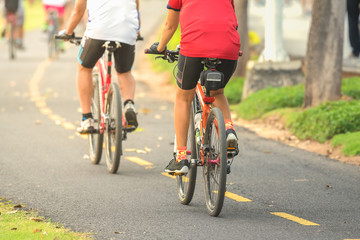 Fototapeta premium Cyclists ride along bike path in park
