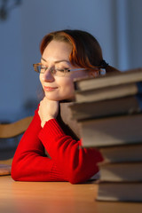 girl reading a book in the library under the lamp