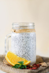 Chia seed pudding in a jar on white wooden background