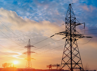 silhouette of power lines in the factory and sunset background.