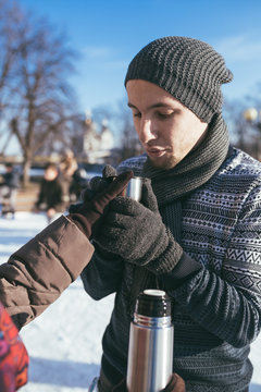 Man portrait at ice-skating rink drinking warm tea. 