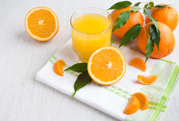 Fresh orange juice in a glass on a background of fruit baskets