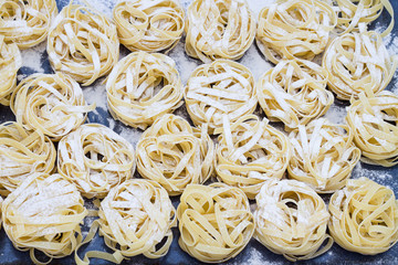  Italian pasta and flour on the dark blue background. Top view.