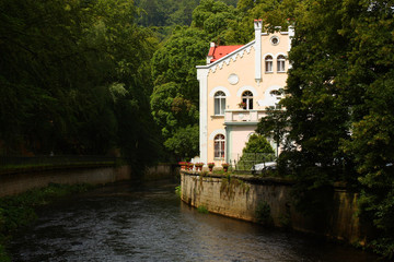 Fototapeta na wymiar A yellow building near the river. Karlovy Vary (Carlsbad), Czech Republic